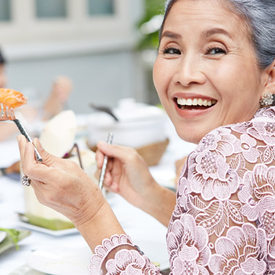 older woman smiling and eating