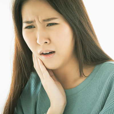 Woman holding face with mouth pain